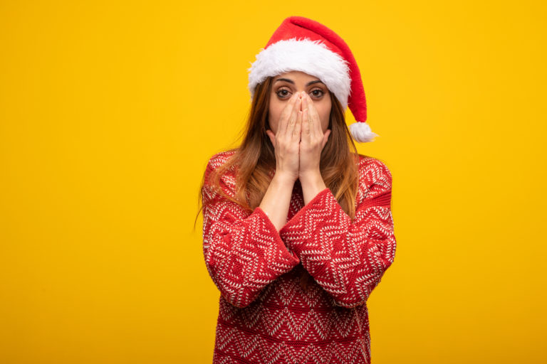 ann-share-price-Young woman wearing santa hat very scared and afraid hidden