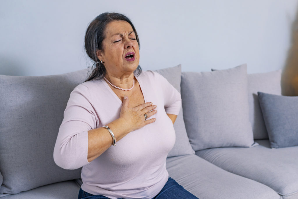 estia-share-price-image-Mature woman holds her heart. Woman having a pain in the heart area. Heart Attack. Painful Chest. Health Care, Medical Concept. High Resolution.
