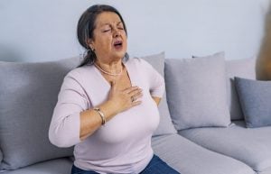 estia-share-price-image-Mature woman holds her heart. Woman having a pain in the heart area. Heart Attack. Painful Chest. Health Care, Medical Concept. High Resolution.