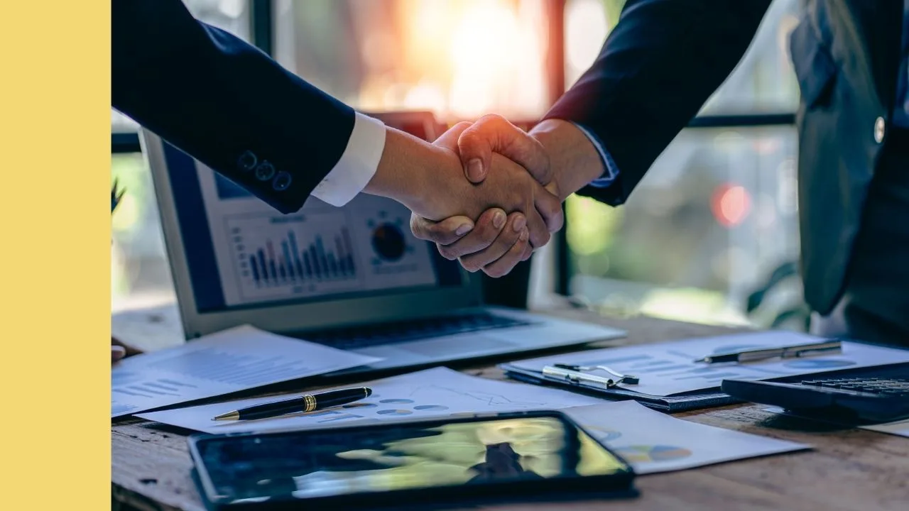 Two corporate leaders shake hands over a business deal