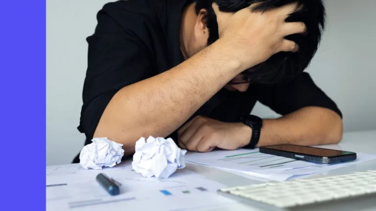 Stressed man with a calculator and screwed up paper trying to make plans