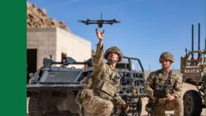 Soldier kneel infront of a vehicle and release an advanced drone into the air