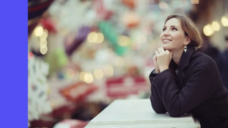 A young woman looks out towards the city lights. She's happy and thinking aspirationally