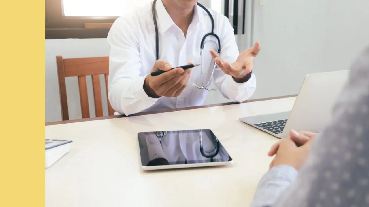 healthcare seeting with a doctor talking to a patient whilst sitting at a desk