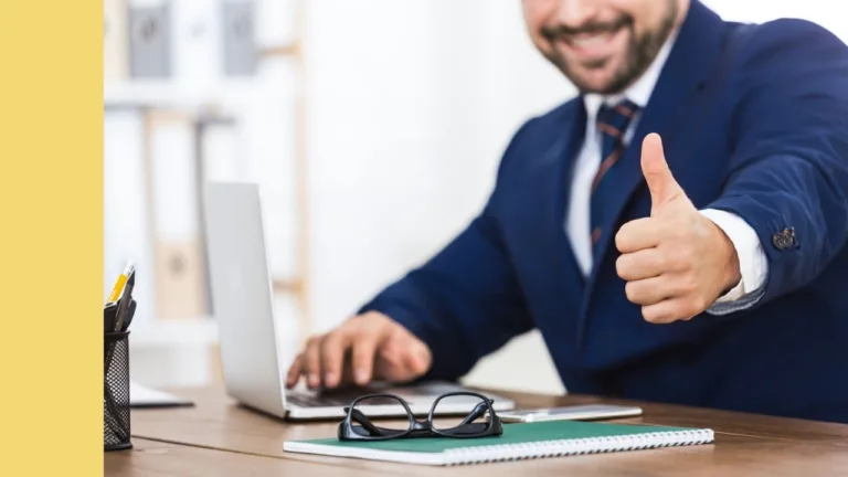 professional male gives thumbs up from behind his desk