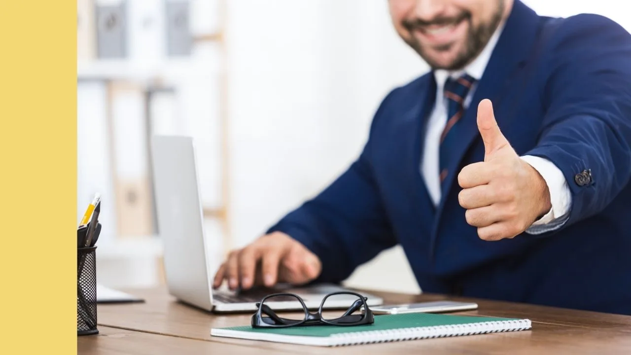 professional male gives thumbs up from behind his desk