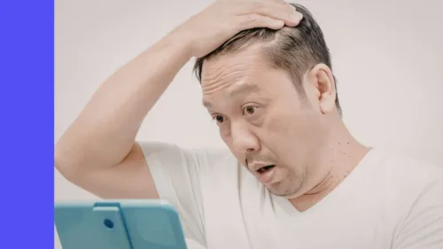 Man looks shocked at what he sees on tablet screen